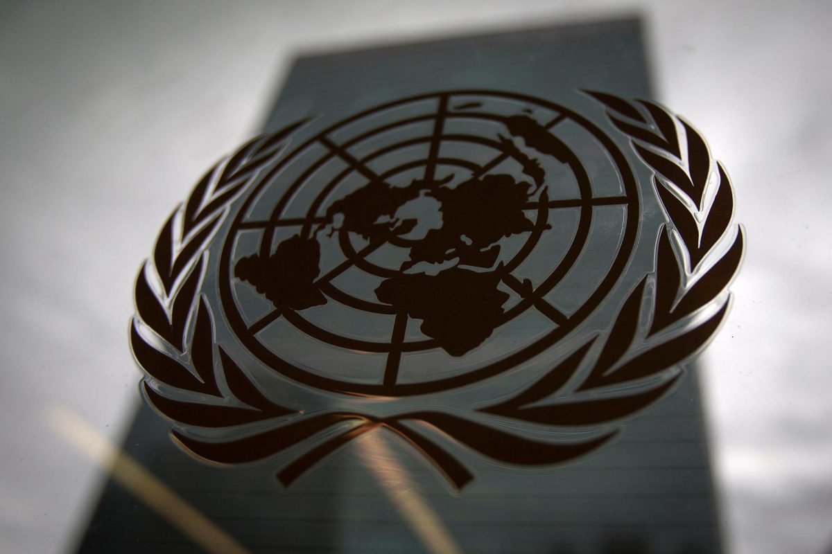 The United Nations headquarters building is pictured though a window with the UN logo in the foreground in the Manhattan borough of New York August 15, 2014.    REUTERS/Carlo Allegri/ File Photo